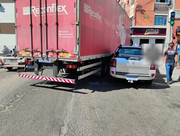 Carro é prensado por caminhão durante manobra no centro de Guanambi.